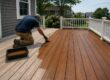 Professional applying stain to a residential deck in Massachusetts